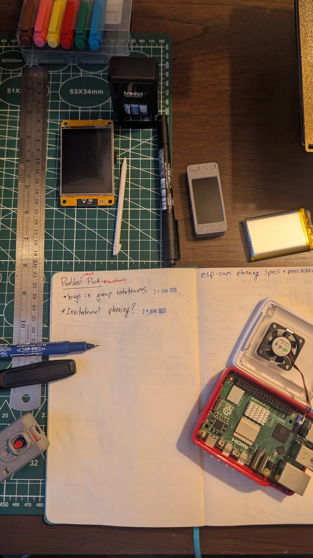 Padlano device components laid out beside handwritten plans