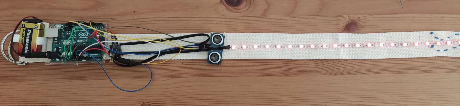 An exposed electronic circuit connected to a long illuminated LED strip