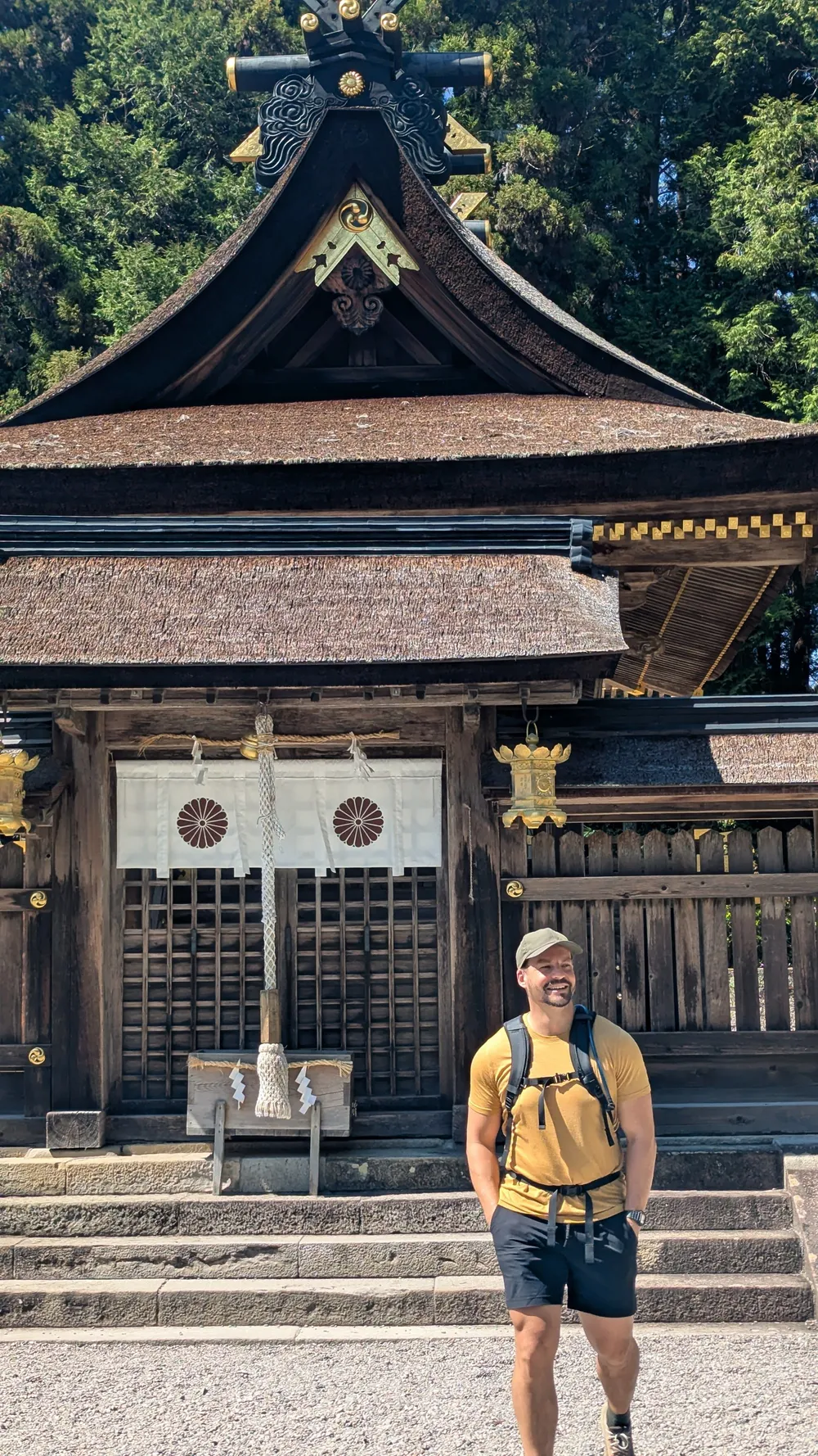 Trevor Cardozo travelling, standing in front of a wooden shrine